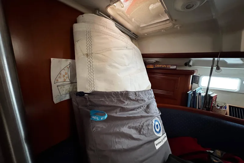 Still In The Moment Yacht Photos Pics Interior of a 2007 Beneteau 423 sailboat with stored sail and books.