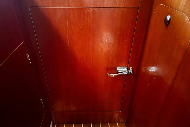 Still In The Moment Yacht Photos Pics Wooden interior door on a 2007 Beneteau 423 yacht, featuring a metal latch.