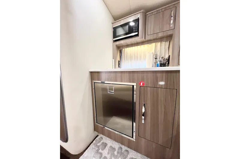 Aventuras Yacht Photos Pics 2021 Regal 33 XO boat interior kitchen with microwave and stainless steel fridge.