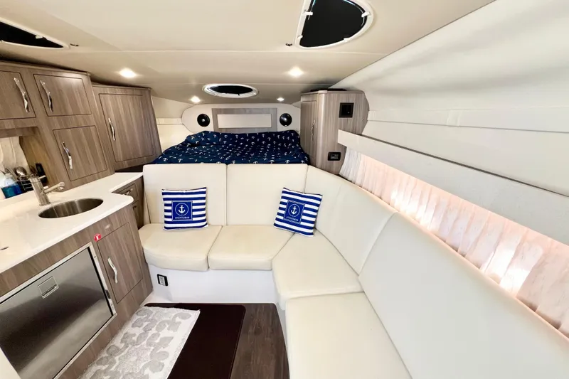 Aventuras Yacht Photos Pics Luxurious interior of 2021 Regal 33 XO yacht with modern kitchen and cozy seating area.