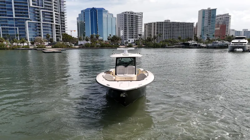  Yacht Photos Pics 2024 Scout 377 LXF boat on water with city skyline background.