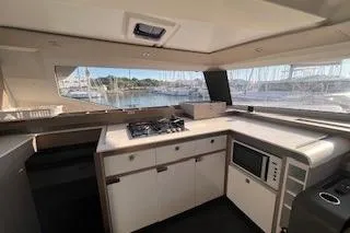  Yacht Photos Pics Modern kitchen interior of 2022 Fountaine Pajot Elba 45 catamaran with stove and microwave.