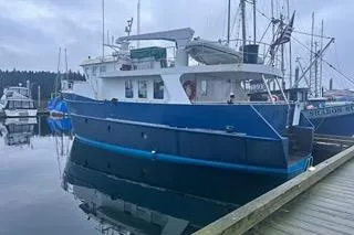 Where To Yacht Photos Pics Cape Horn Trawler 2000 docked at a marina, overcast sky, calm water reflection.