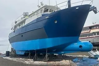Where To Yacht Photos Pics 2000 Cape Horn Trawler on dry dock, blue hull, maintenance underway.