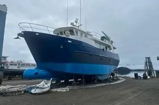 Where To Yacht Photos Pics Cape Horn Trawler 2000 on dry dock, blue hull, overcast sky.