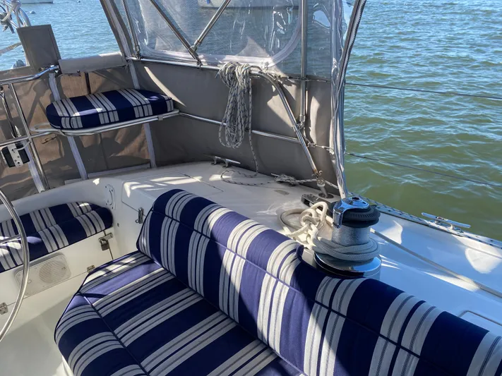  Yacht Photos Pics Cockpit of 2001 Catalina 42 MkII sailboat with striped seating and winch, overlooking water.