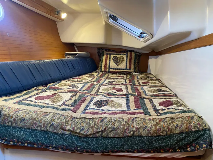  Yacht Photos Pics Cozy cabin interior of 2001 Catalina 42 MkII with patterned bedding and blue cushion.