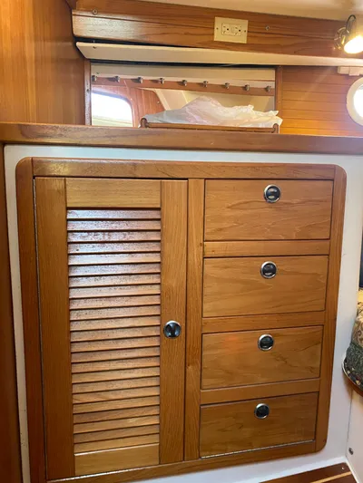  Yacht Photos Pics Wooden cabinetry inside a 2001 Catalina 42 MkII sailboat, featuring drawers and a louvered door.
