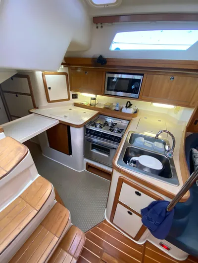  Yacht Photos Pics 2001 Catalina 42 MkII yacht interior with kitchen, stove, sink, and wooden cabinetry.