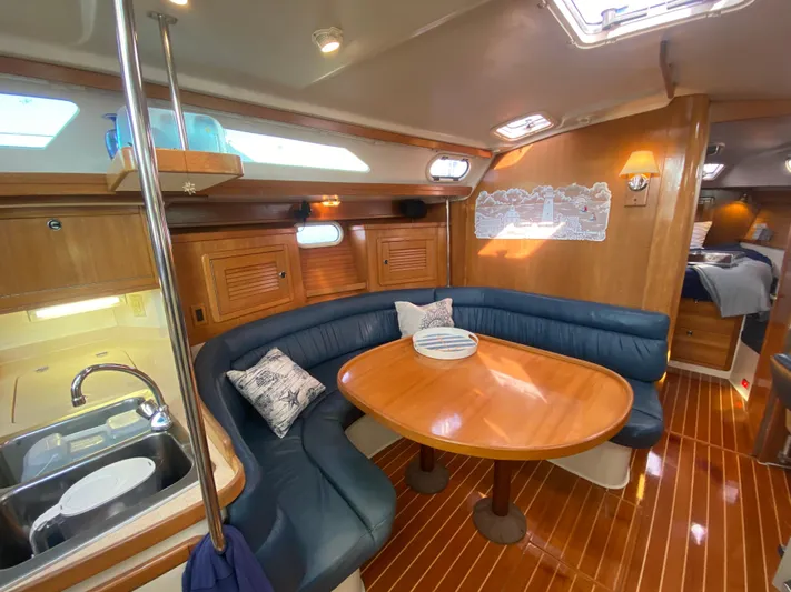  Yacht Photos Pics Interior of 2001 Catalina 42 MkII sailboat with wooden dining area and blue seating.