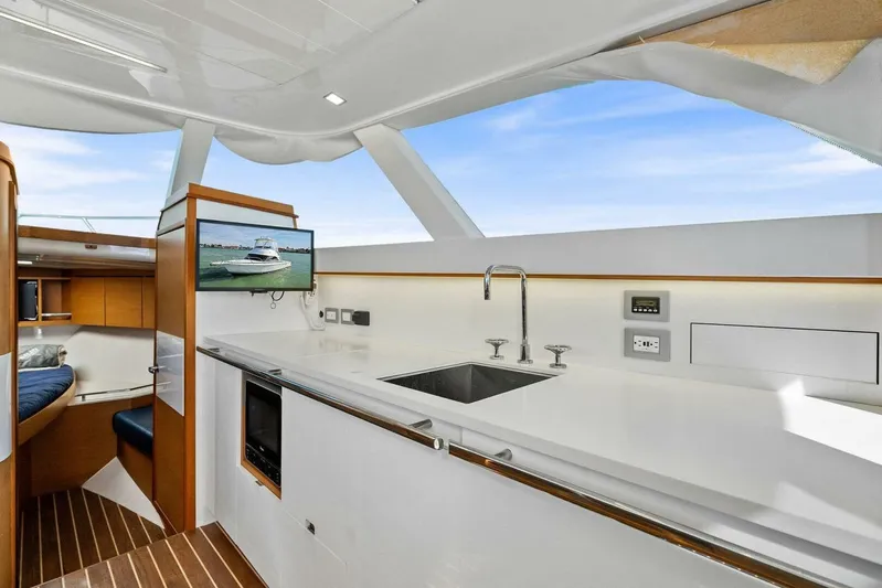 Still Dancing Yacht Photos Pics Modern interior of 2017 Bertram 35 Flybridge yacht with sleek kitchen and cozy cabin.