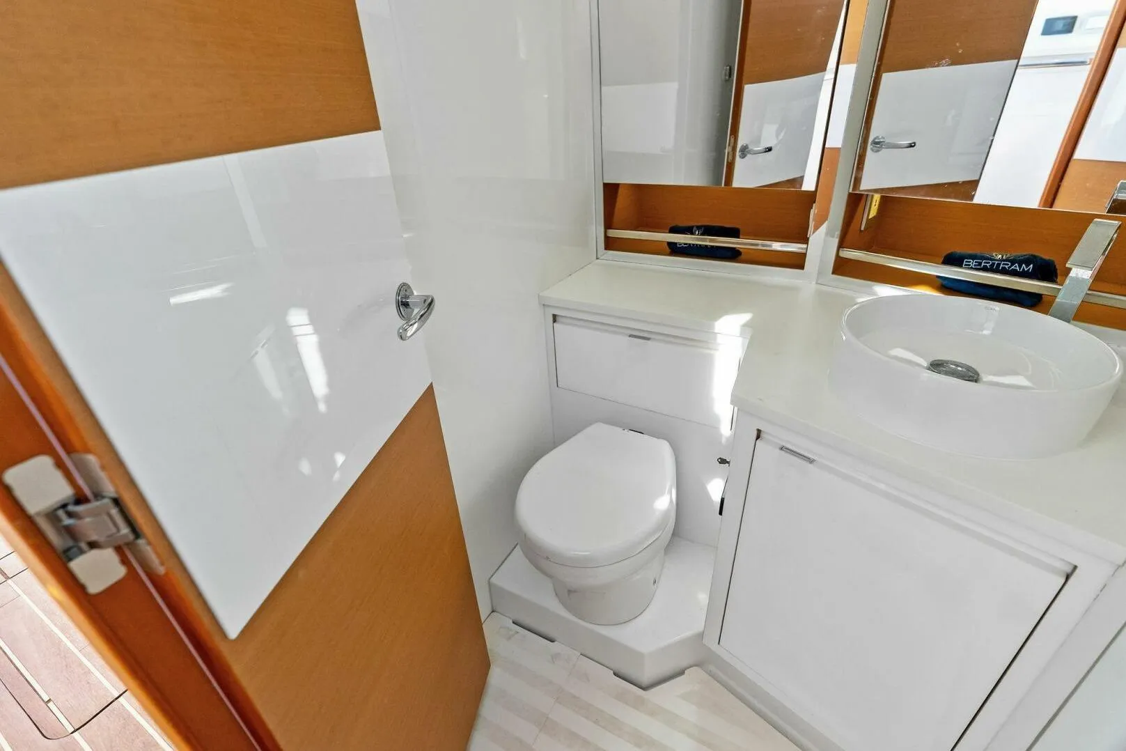 Modern bathroom in 2017 Bertram 35 Flybridge yacht with sleek fixtures and mirror.