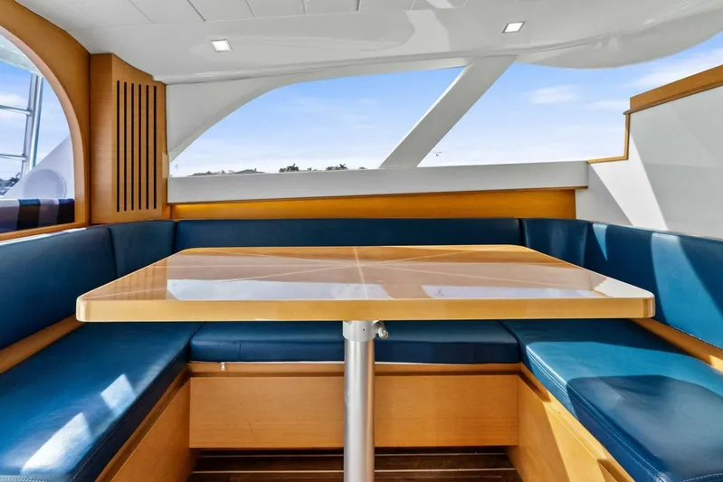 Still Dancing Yacht Photos Pics Interior of 2017 Bertram 35 Flybridge with blue seating and wooden table.
