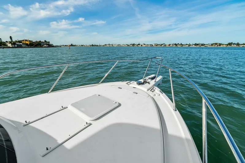 Still Dancing Yacht Photos Pics 2017 Bertram 35 Flybridge boat on calm waters under a clear blue sky.