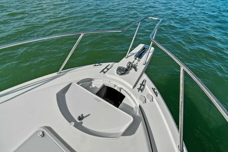 Still Dancing Yacht Photos Pics 2017 Bertram 35 Flybridge boat bow with anchor, railing, and open hatch on calm water.