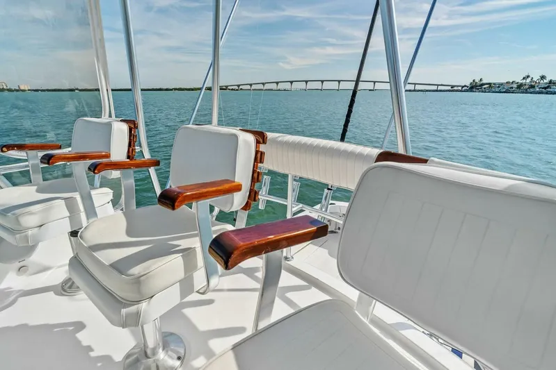 Still Dancing Yacht Photos Pics 2017 Bertram 35 Flybridge boat with white seating, overlooking serene water and distant bridge.