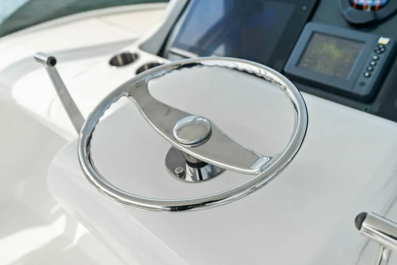 Still Dancing Yacht Photos Pics Steering wheel of 2017 Bertram 35 Flybridge yacht with navigation controls.