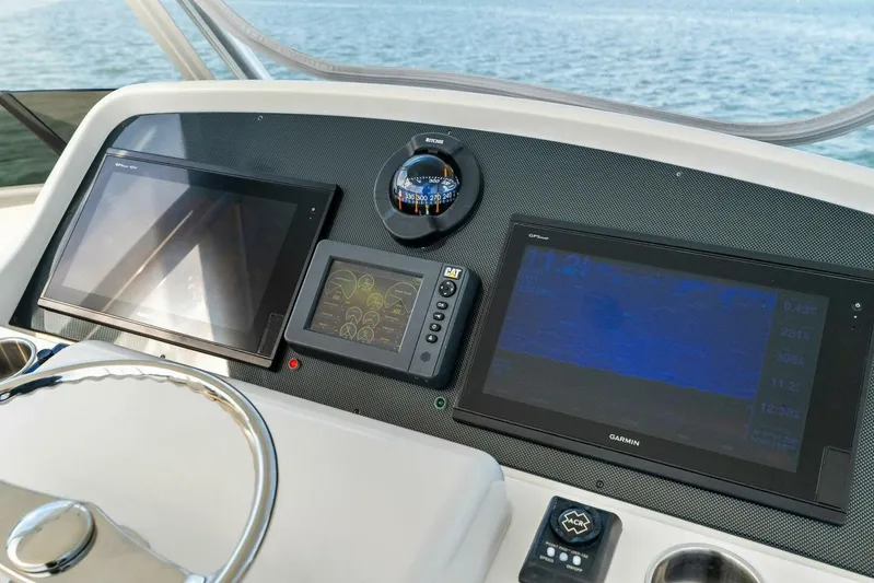 Still Dancing Yacht Photos Pics 2017 Bertram 35 Flybridge helm with advanced navigation displays and steering wheel.