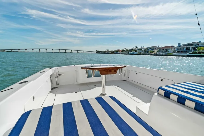 Still Dancing Yacht Photos Pics 2017 Bertram 35 Flybridge boat with striped seating, scenic waterfront view.