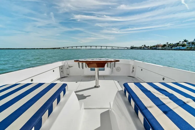 Still Dancing Yacht Photos Pics 2017 Bertram 35 Flybridge boat with striped seating, scenic water view, and distant bridge.