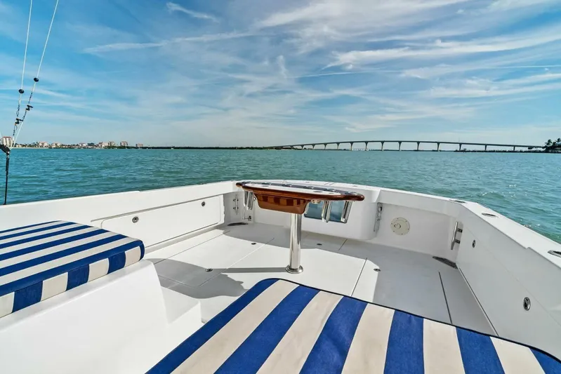Still Dancing Yacht Photos Pics 2017 Bertram 35 Flybridge boat with striped seating, ocean view, and distant bridge.