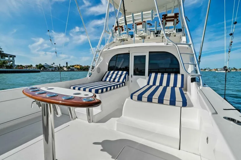 Still Dancing Yacht Photos Pics 2017 Bertram 35 Flybridge yacht with striped seating, docked on a sunny day.