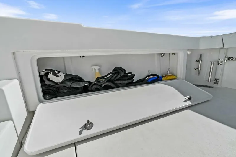 Still Dancing Yacht Photos Pics Storage compartment on a 2017 Bertram 35 Flybridge boat, containing ropes and cleaning supplies.