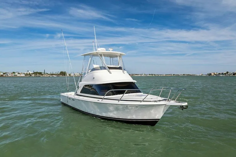 Still Dancing Yacht Photos Pics 2017 Bertram 35 Flybridge boat on calm water under blue sky.