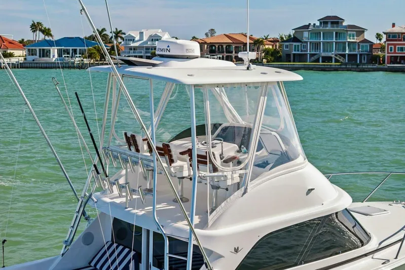 Still Dancing Yacht Photos Pics 2017 Bertram 35 Flybridge yacht on turquoise water near luxury waterfront homes.