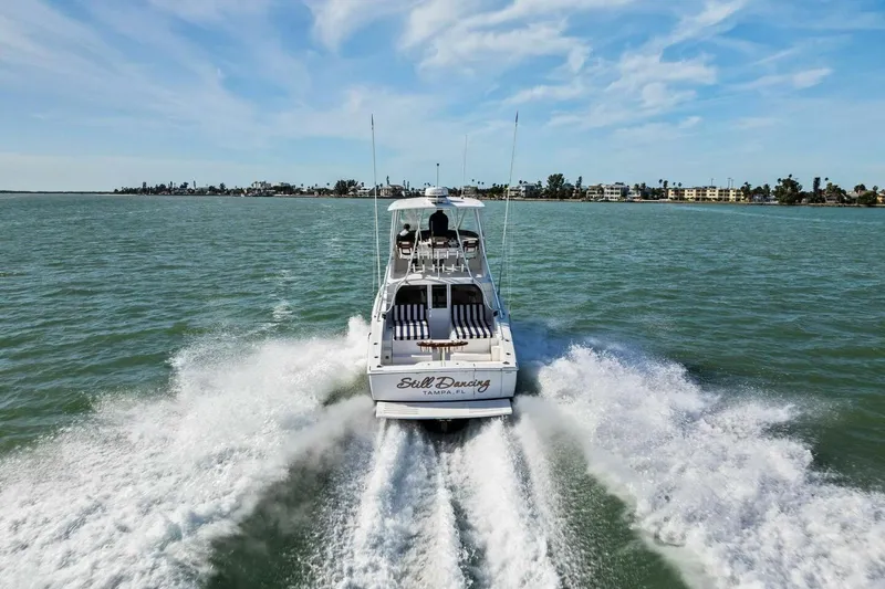 Still Dancing Yacht Photos Pics 2017 Bertram 35 Flybridge cruising on open water, leaving a wake behind.