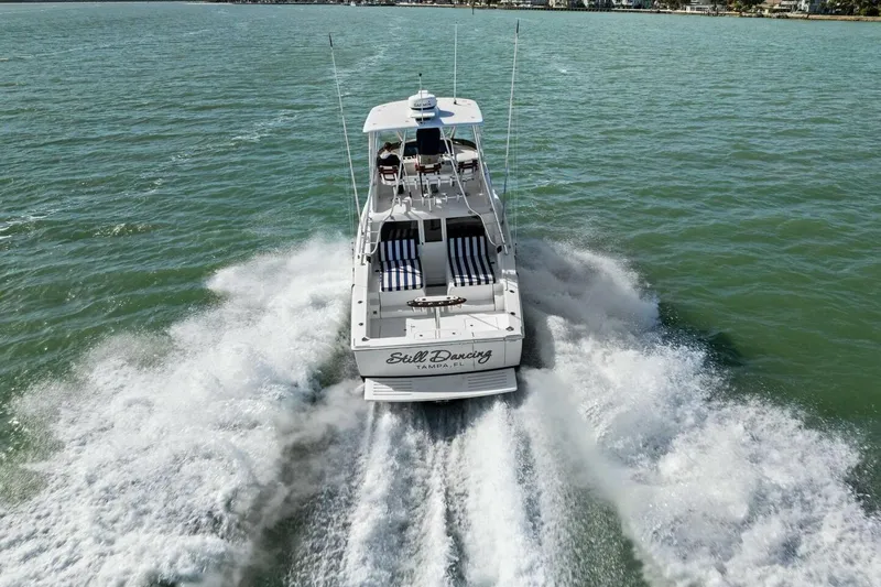 Still Dancing Yacht Photos Pics 2017 Bertram 35 Flybridge cruising on open water, creating a dynamic wake.