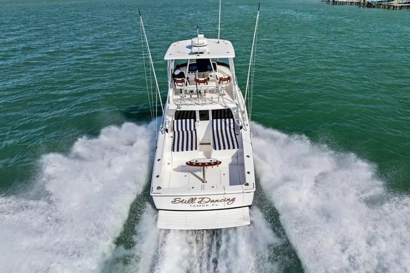 Still Dancing Yacht Photos Pics 2017 Bertram 35 Flybridge cruising on open water, rear view.