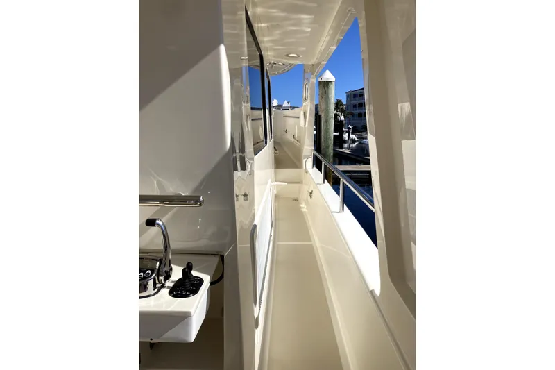 Grace Yacht Photos Pics Side deck view of 2019 Marlow 49E yacht, showcasing sleek design and marina backdrop.