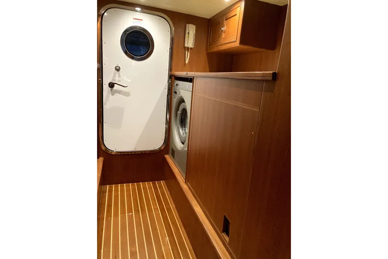 Grace Yacht Photos Pics Laundry area in 2019 Marlow 49E yacht with wooden flooring and porthole door.