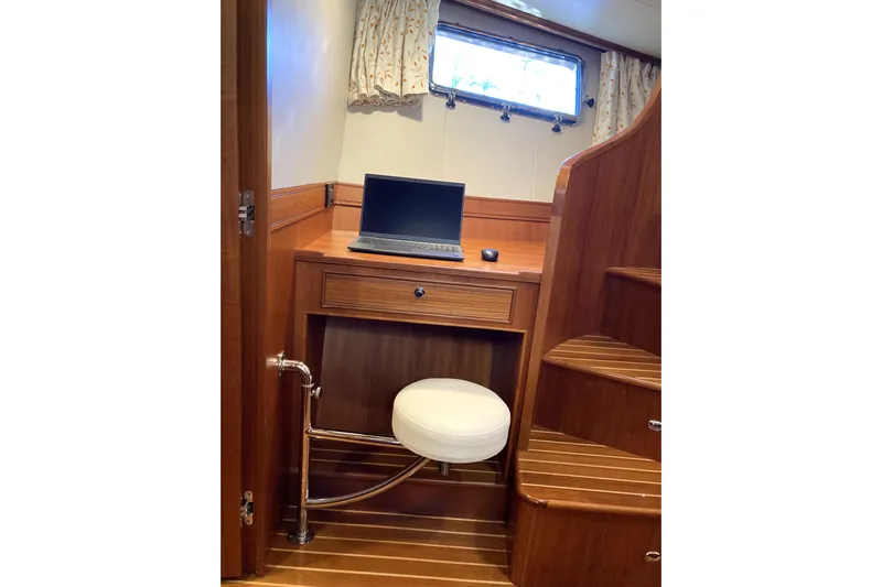 Grace Yacht Photos Pics Compact workspace on 2019 Marlow 49E yacht with laptop and wooden interior.