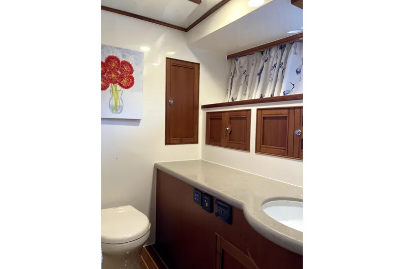 Grace Yacht Photos Pics Luxurious Marlow 49E 2019 yacht bathroom with elegant wood cabinetry and floral artwork.