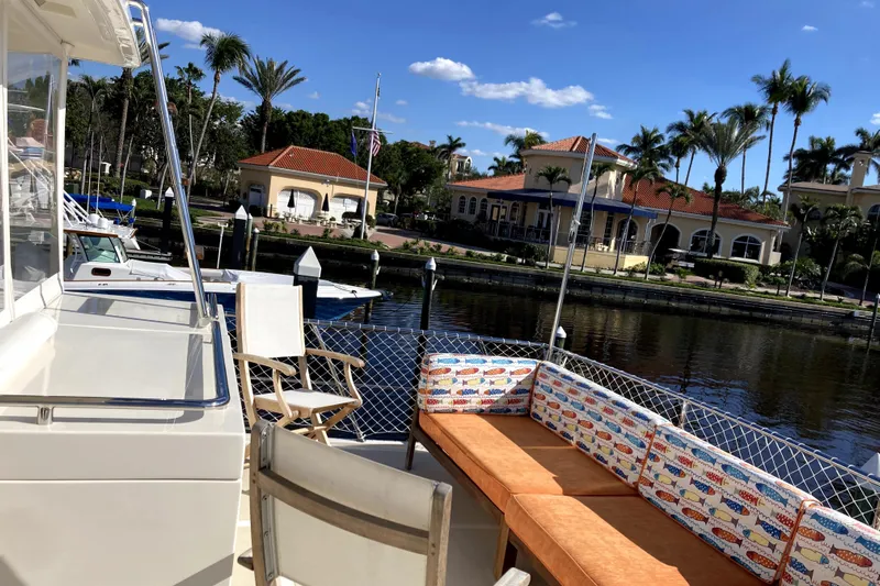 Grace Yacht Photos Pics 2019 Marlow 49E yacht deck with seating, docked near waterfront homes and palm trees.