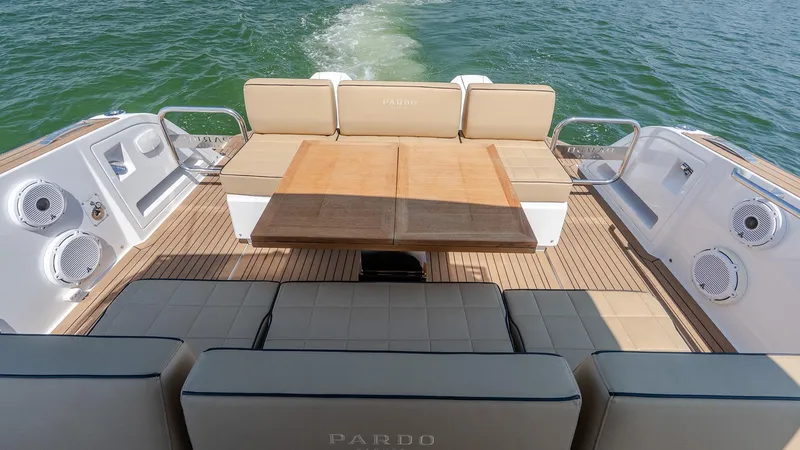  Yacht Photos Pics Luxury seating area on 2023 Pardo Yachts P38, featuring elegant wood table and cushioned seats.