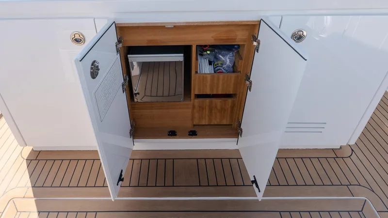  Yacht Photos Pics Open storage compartment on 2023 Pardo Yachts P38, featuring wooden interior and organized shelves.