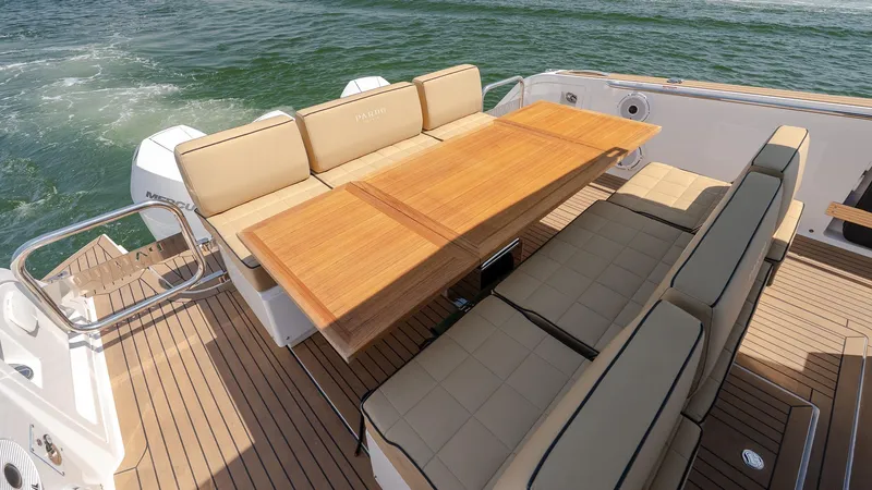  Yacht Photos Pics Luxury seating area on 2023 Pardo Yachts P38, featuring elegant wooden table and cushioned seats.