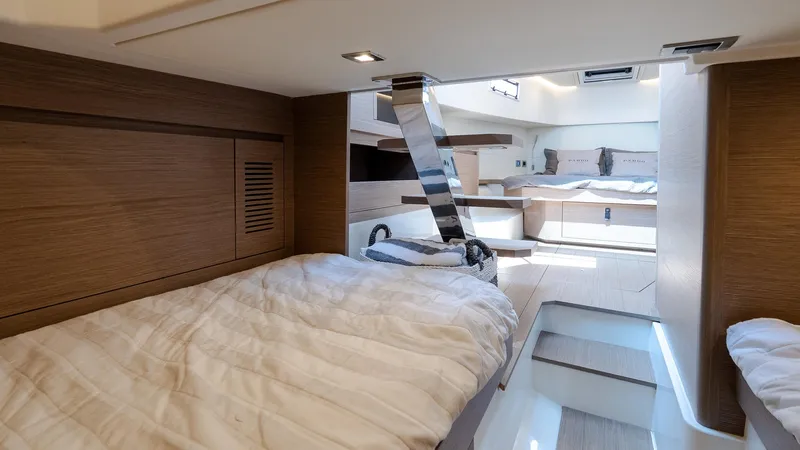  Yacht Photos Pics Luxurious interior of 2023 Pardo Yachts P38, featuring modern wood finishes and cozy bedding.