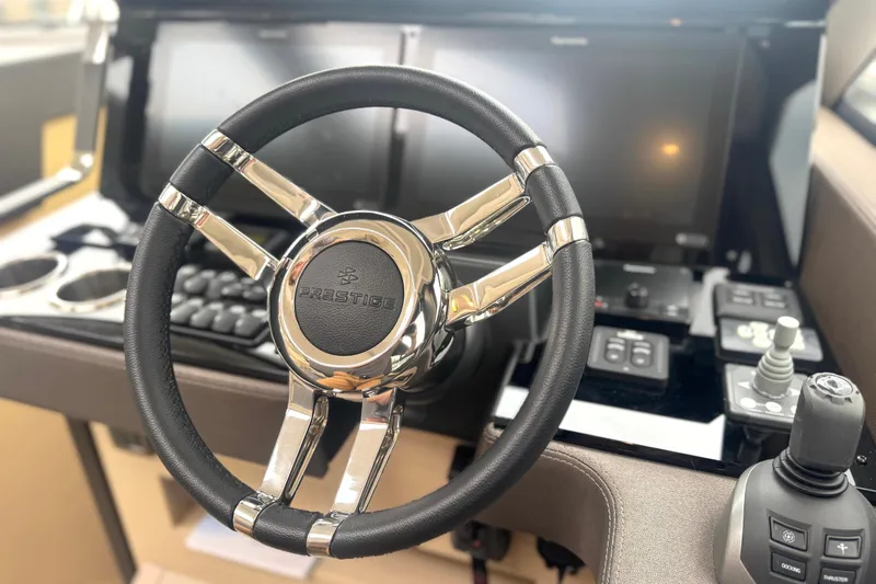 Serenity Yacht Photos Pics Steering wheel of 2023 Prestige 460S yacht with modern dashboard controls.