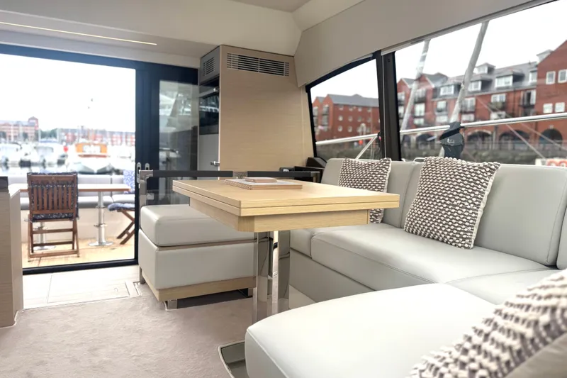 Serenity Yacht Photos Pics Luxurious interior of 2023 Prestige 460S yacht with modern seating and marina view.