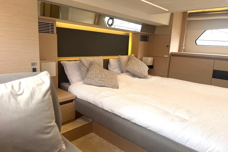 Serenity Yacht Photos Pics Luxurious bedroom interior of 2023 Prestige 460S yacht, featuring modern design and cozy bedding.