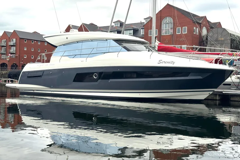 Serenity Yacht Photos Pics 2023 Prestige 460S yacht docked in a marina, reflecting on calm water.
