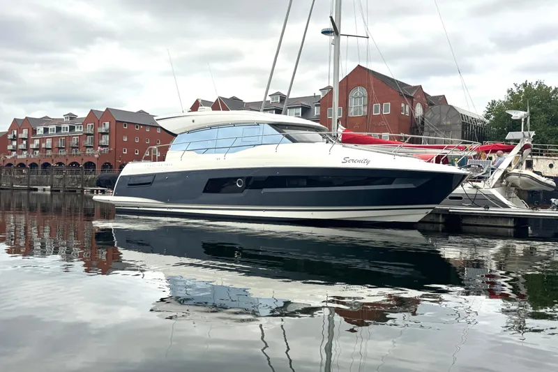 Serenity Yacht Photos Pics 2023 Prestige 460S yacht docked in a marina, reflecting on calm water.