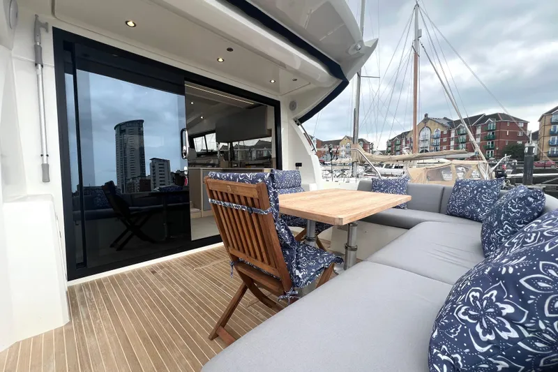 Serenity Yacht Photos Pics Luxurious 2023 Prestige 460S yacht with elegant outdoor seating and marina view.