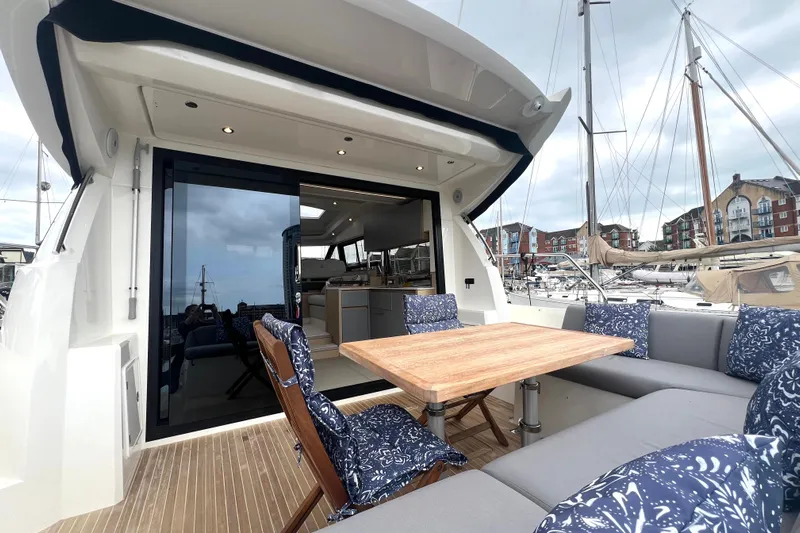 Serenity Yacht Photos Pics Luxurious 2023 Prestige 460S yacht with elegant outdoor seating and wooden table.