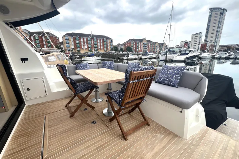 Serenity Yacht Photos Pics Luxurious 2023 Prestige 460S yacht deck with elegant seating and marina view.