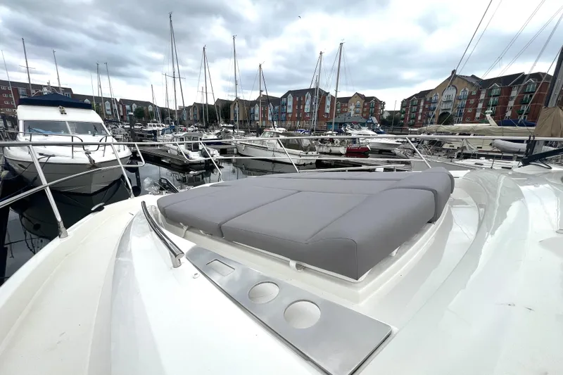 Serenity Yacht Photos Pics Prestige 460S 2023 yacht in marina, featuring sleek design and comfortable sunbathing area.